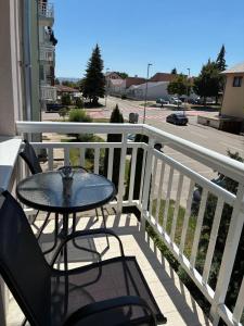 a table and chairs on a balcony with a view of a street at Apartment S&S Tomislavgrad in Tomislavgrad