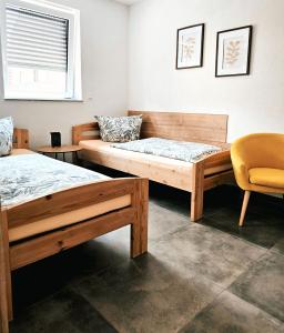two beds in a room with a chair at Eibauer Apartments in Sinsheim +112 photos
