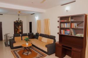 a living room with a couch and a piano at The Villa Mahogany in Trivandrum