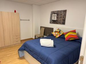 a bedroom with a blue bed and a chair at Hostal Vaticano in Alfajarín