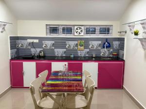 a kitchen with a table and chairs and a counter at The Villa Mahogany in Trivandrum