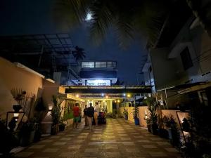 a group of people walking down a street at night at The Villa Mahogany in Trivandrum