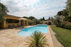 a swimming pool in a yard with a patio at Maison de campagne mas Célestin in Camaret-sur-Aigues