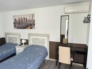 a bedroom with two beds and a desk and a desk at Hostal Vaticano in Alfajarín