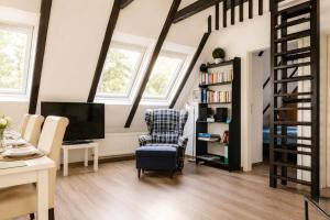 a living room with a chair and a book shelf at Zugvogel OG in Wangerland