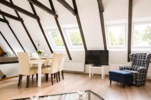 a living room with a table and chairs and a tv at Zugvogel OG in Wangerland