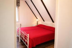 a bedroom with a red bed with a red blanket at Zugvogel OG in Wangerland