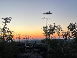 a set of swings with the sunset in the background at Am Holundergrund in Kurort Gohrisch +3 photos