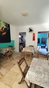 a room with tables and chairs and a bedroom at Pousada Preguiça in Canoa Quebrada