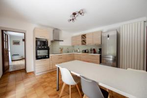a kitchen with a white table and white chairs at Maison de campagne mas Célestin in Camaret-sur-Aigues