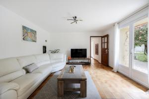 a living room with a white couch and a table at Maison de campagne mas Célestin in Camaret-sur-Aigues