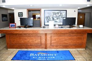 a reception desk with two monitors on top of it at Baymont Inn And Suites by Wyndham Platteville in Platteville