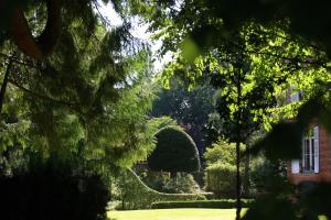 a view of a garden with a house and trees at Chambre d'hôtes du Château de Digeon in Morvillers-Saint-Saturnin