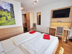 a bedroom with two beds and a flat screen tv at Gasthof Jörns in Diekholzen