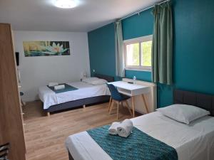 a room with two beds and a table and a desk at Centre Louis Ormières in Montauban +12 photos