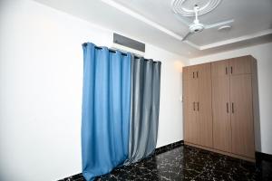 ein Zimmer mit zwei blauen Vorhängen und einem Kleiderschrank in der Unterkunft Motion apt in Accra + 6 Fotos