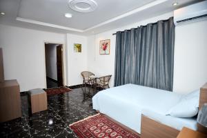 ein Schlafzimmer mit einem Bett, einem Tisch und Stühlen in der Unterkunft Motion apt in Accra
