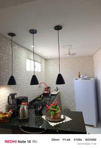 a kitchen with a black counter and a white refrigerator at Casa Toda com Garagem a 3km do Aeroporto in Teresina +2 photos