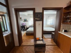 a room with two mirrors and a living room at Safely located apartment in Prishtinë