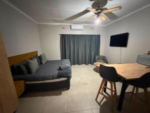 a bedroom with a bed and a dining room table at Green Haven Waitara in Tzaneen