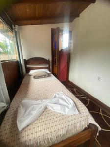 ein Schlafzimmer mit einem Bett, auf dem ein Bademantel liegt in der Unterkunft Biergarten Hostel in Abraão