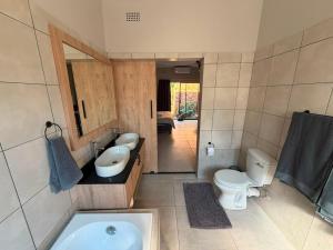 a bathroom with a sink and a toilet and a tub at Green Haven Waitara in Tzaneen