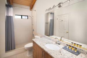 a bathroom with a sink and a toilet and a mirror at Nama-Stay Retreat Village in Springdale