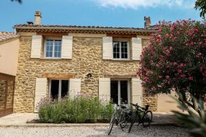 a stone house with bikes parked in front of it at Maison de campagne mas Célestin in Camaret-sur-Aigues