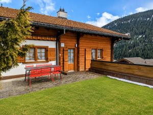 a house with a table and chairs in front of it at Maisonette-Wohnung in Rueras bei Sedrun - 200m zum Bahnhof - Perfekt für Ski & Ausflüge in Rueras