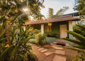 a small green house with a pathway in front of it at Lax Stays Morjim by SevenTales in Morjim