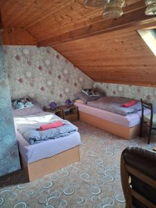 a room with two beds in a attic at Penzion Krušnohorka in Tatrovice