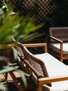 a wooden chair sitting next to a plant at Hotel de Paris in La Rochelle
