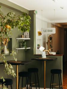 a bar with stools in a room with green walls at Hotel de Paris in La Rochelle