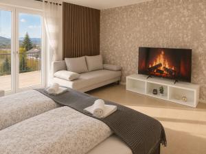a bedroom with a bed and a tv and a couch at Rheinview Sunset in Urbar in Urbar