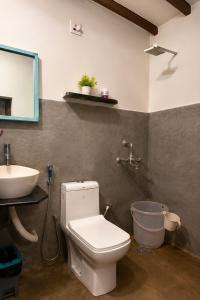 a bathroom with a white toilet and a sink at Lax Stays Morjim by SevenTales in Morjim