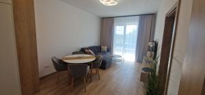 a living room with a table and a couch at Forest Nest - Livezeni in Livezeni
