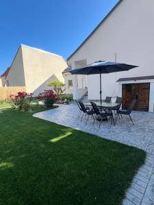 a patio with a table and chairs and an umbrella at Casa Racolța Central Garden in Câmpia Turzii