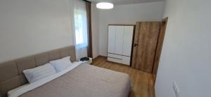a bedroom with a white bed and a mirror at Forest Nest - Livezeni in Livezeni