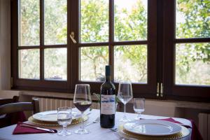 a bottle of wine sitting on a table with glasses at Agriturismo La Cipriana in Castagneto Carducci