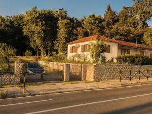a car parked in front of a house with a fence at Casa Hollaj in Vladimir