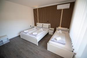 two beds in a room with white furniture at Guesthouse Siva Čaplja in Ptuj