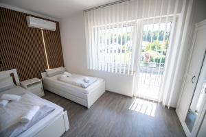 a white room with a bed and a window at Guesthouse Siva Čaplja in Ptuj