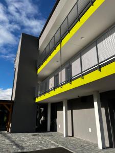 a large building with a yellow and gray at Bi Apartments in KoÅ¡ickÃ© KÃºpele