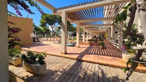 a wooden deck with a pergola and potted plants at Leman Hotel y Apartamentos in Playa de Palma