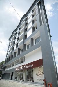 a large building with a store in front of it at Rivayn Suites in Thiruvalla