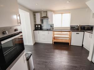 a kitchen with white cabinets and a wooden floor at Number 3 Old Boston Road in Lincoln +9 photos
