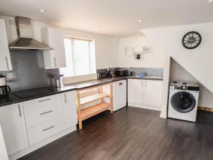 a kitchen with white cabinets and a washer and dryer at Number 3 Old Boston Road in Lincoln