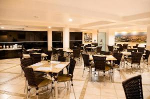 a restaurant with tables and chairs in a room at Cedro Hotel in Londrina