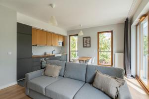 a living room with a couch and a kitchen at Warsaw Concierge Gocławek in Warsaw