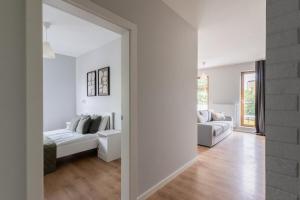 a white living room with a couch and a table at Warsaw Concierge Gocławek in Warsaw